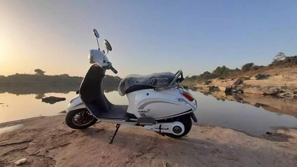 PureEv ePluto7G Silver color scooter standing beside water